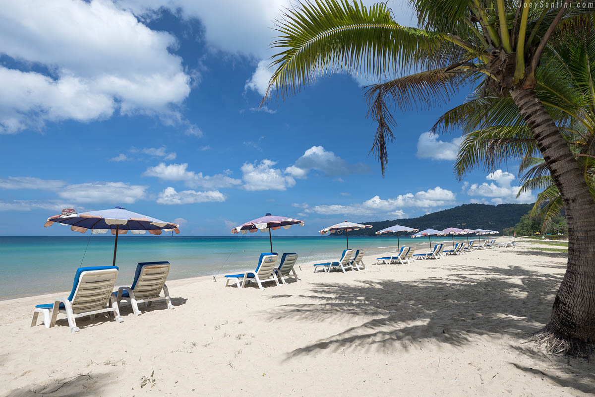 White sand with loungers and umbrellas and blue sky in the background