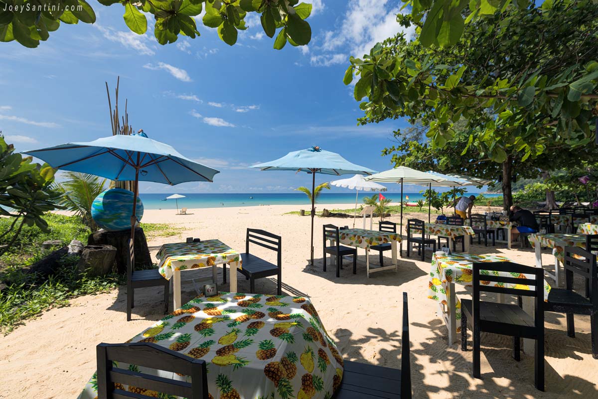 Showing few tables and umbrellas with blue sky in the background