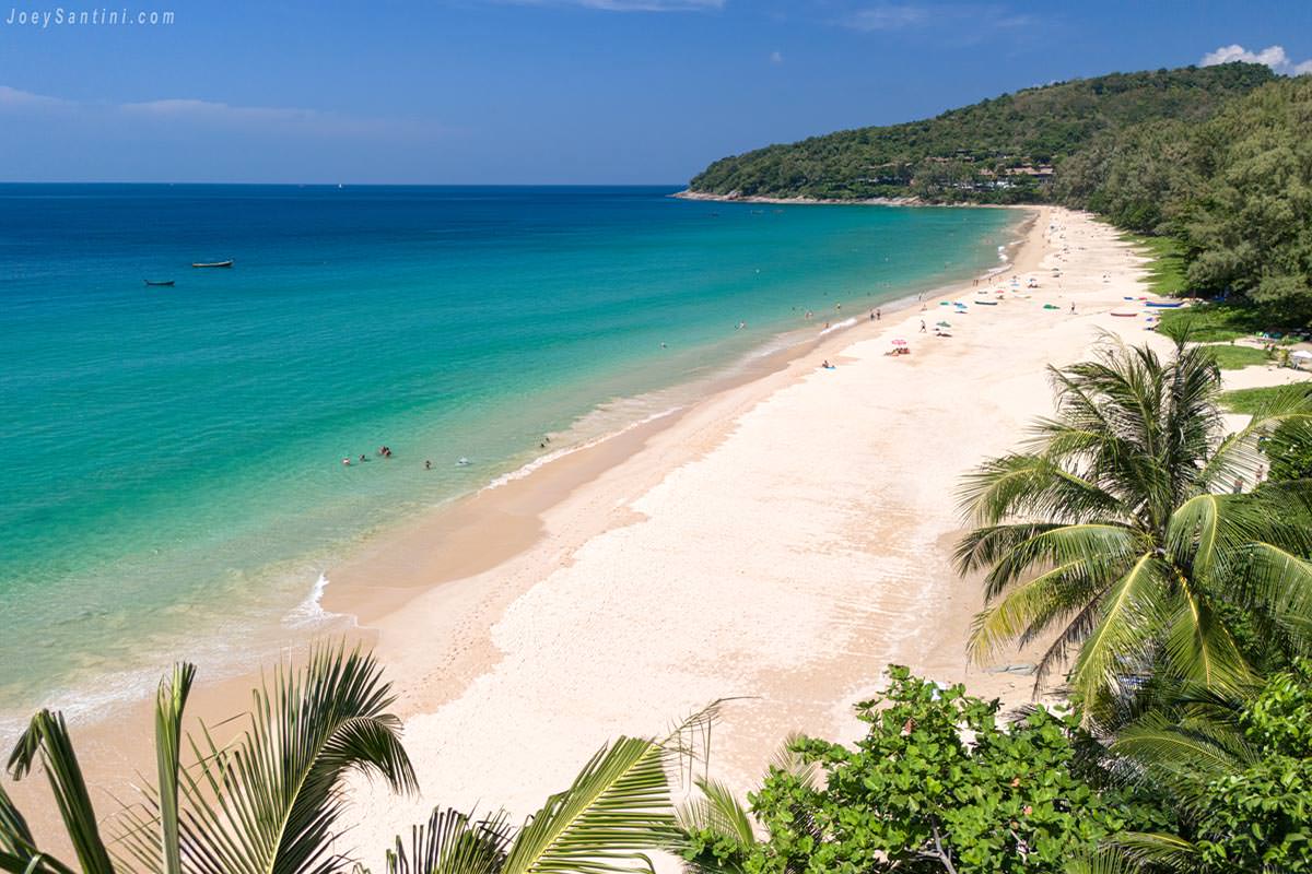 Aerial view of Naithon Beach's turquoise water, golden sand, and lush jungle.