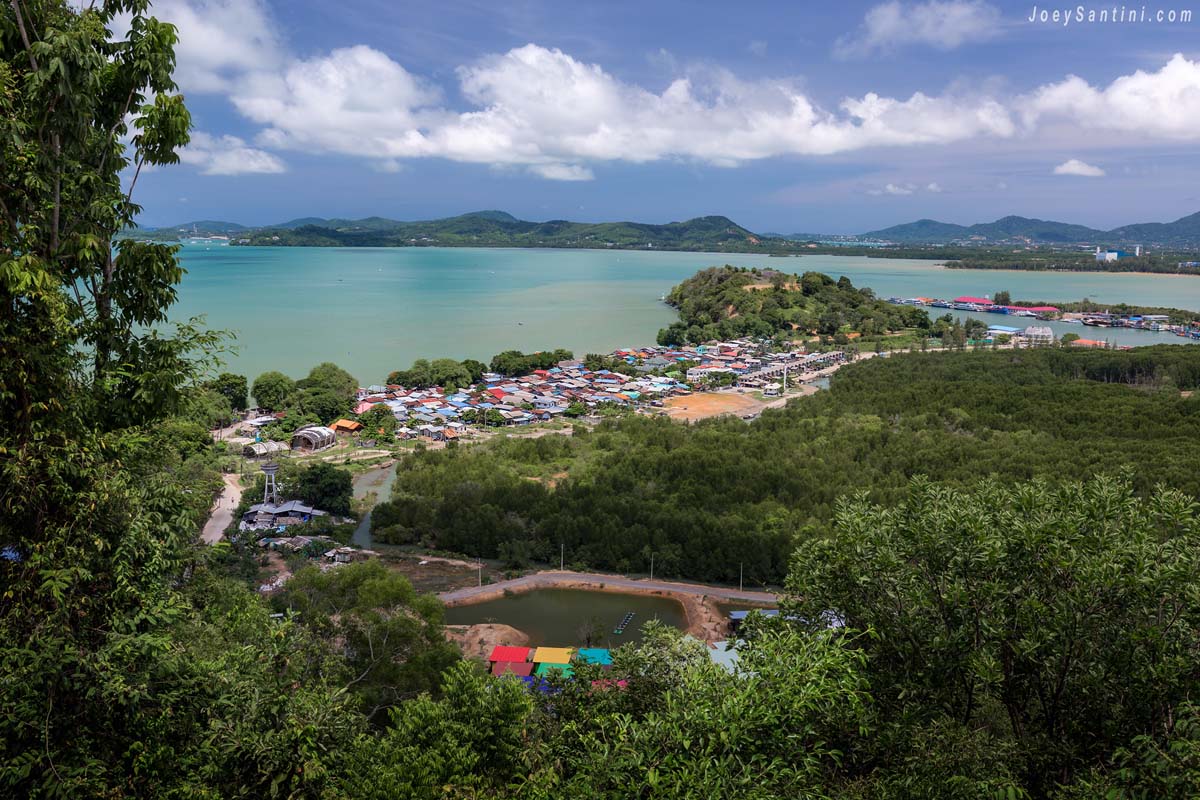 Panoramic view over the coastline of Koh Siray island Phuket, showing a small village and distant hills