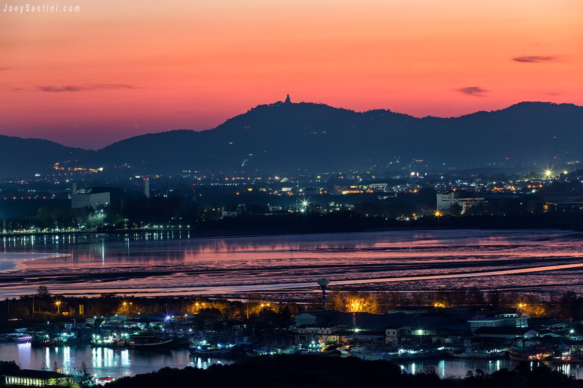 Vibrant twilight view over Phuket town coastline and Big Buddha silhouette from Wat Koh Siray