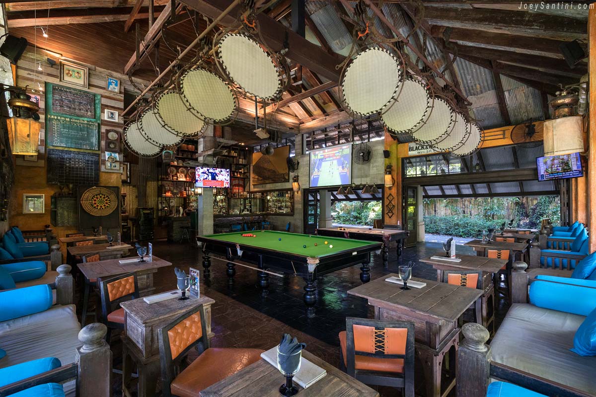 Shot of a bar with brown tables and a green pool table