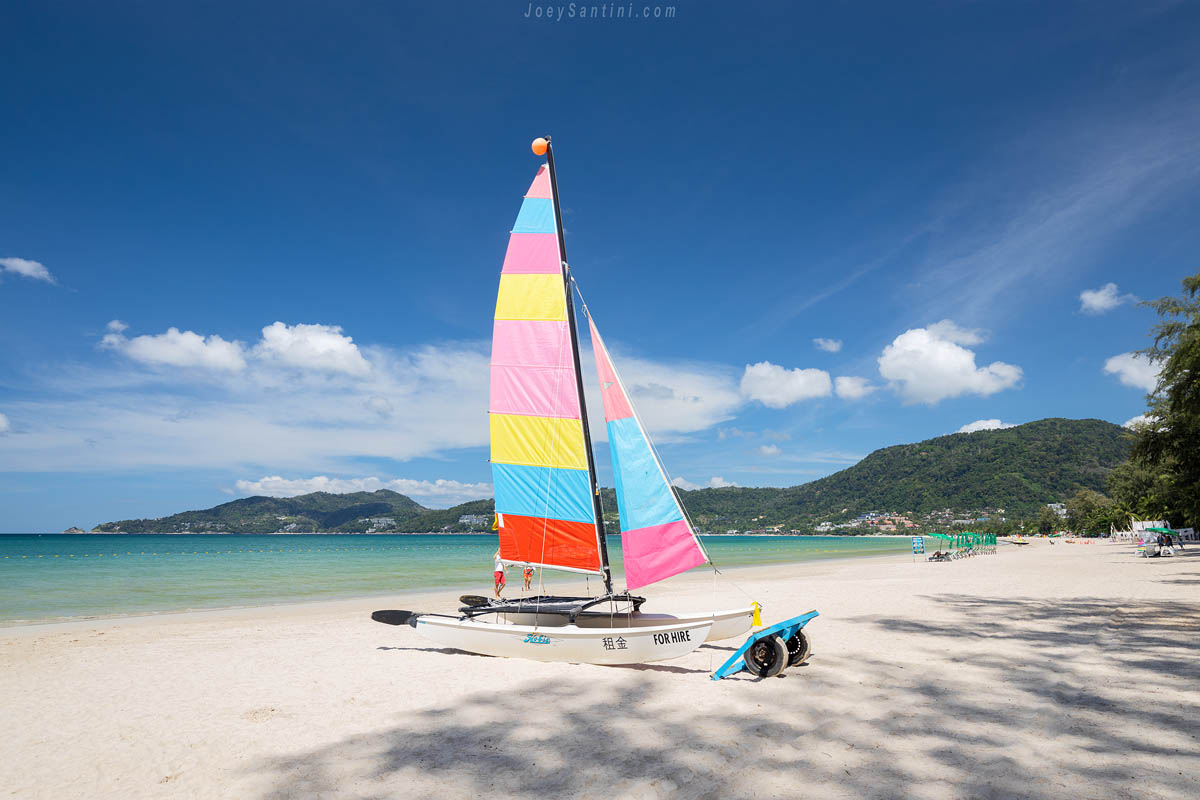 Multi colored sailboat with blue sky in the background