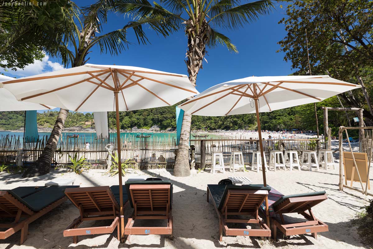 Comfortable sun loungers and large white umbrellas in the relaxing area of Barefoot Bistro at Freedom Beach.