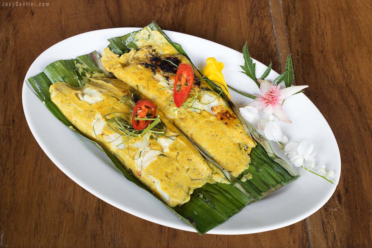 Shot of yellow grilled fish with curry paste in banana leaf
