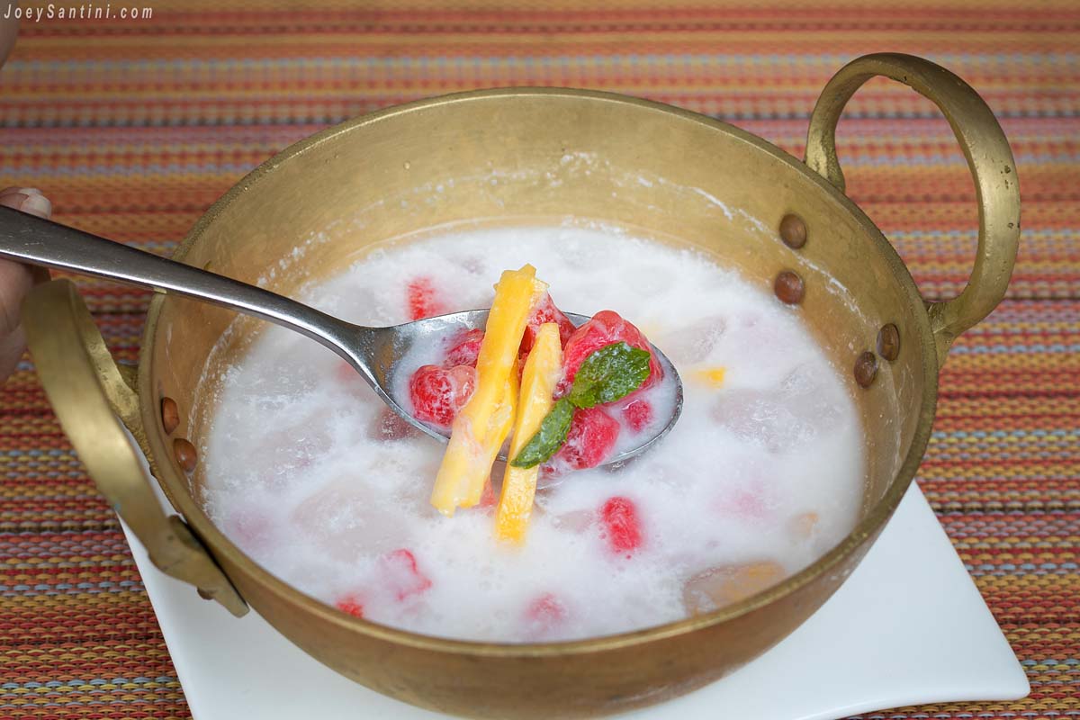 Shot of red and yellow fruits with white soup in a bowl