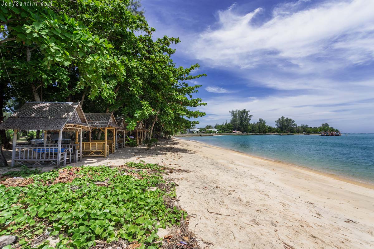 Quiet beach with bamboo huts under the trees