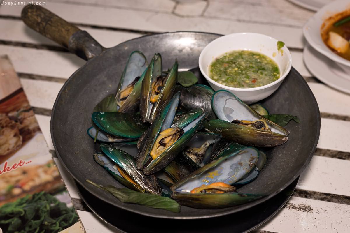 Mussels with green spicy sauce on a metal pan