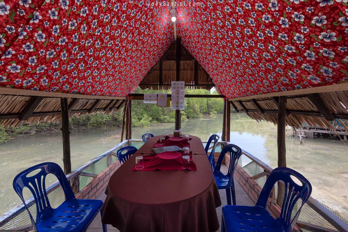 Cabana with red roof and plastic chiars and red table cloth