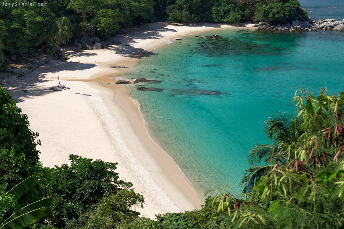 Laem Sing beach with white sand and turquoise waters surrounded by green jungle