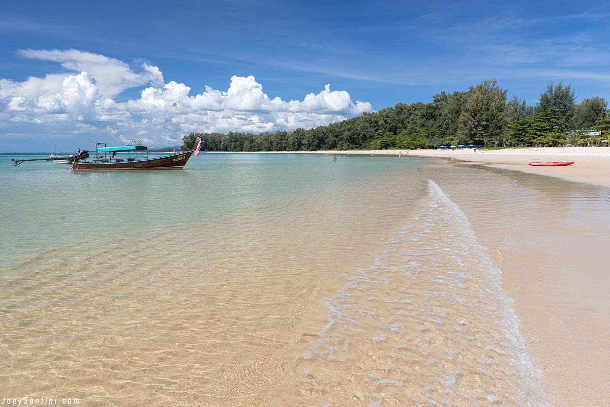 Shot of the clear water of Nai Yang beach with a boat on the left side