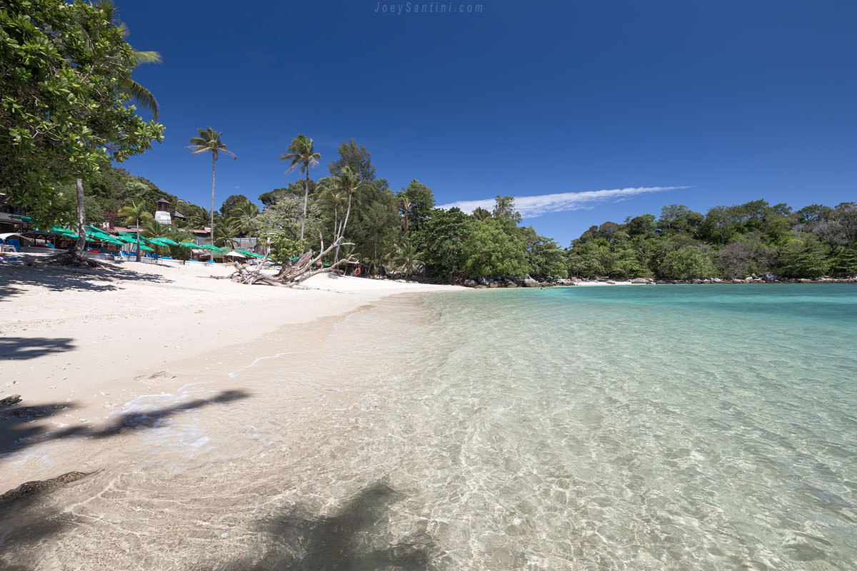 Shot of the white sand and clear sea water with blue sky in the background