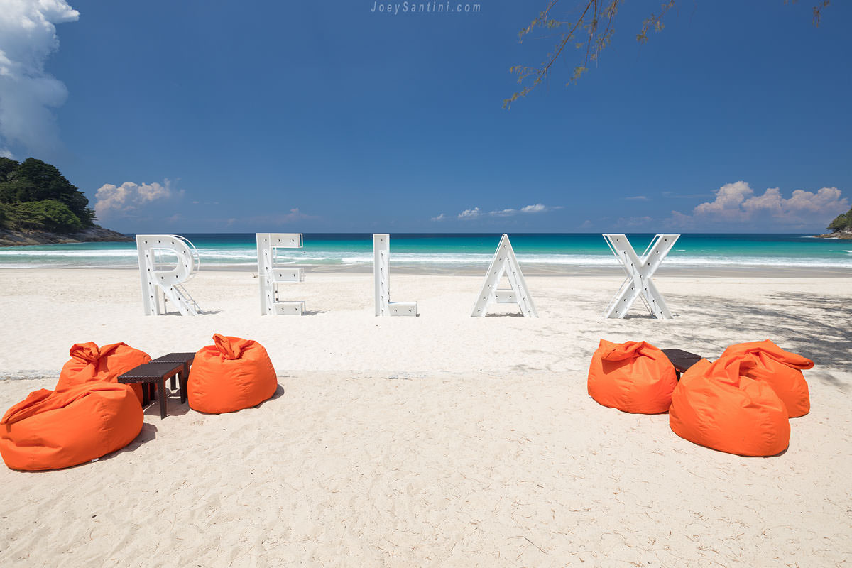 Shot of the orange cushions and the white sand of the beach