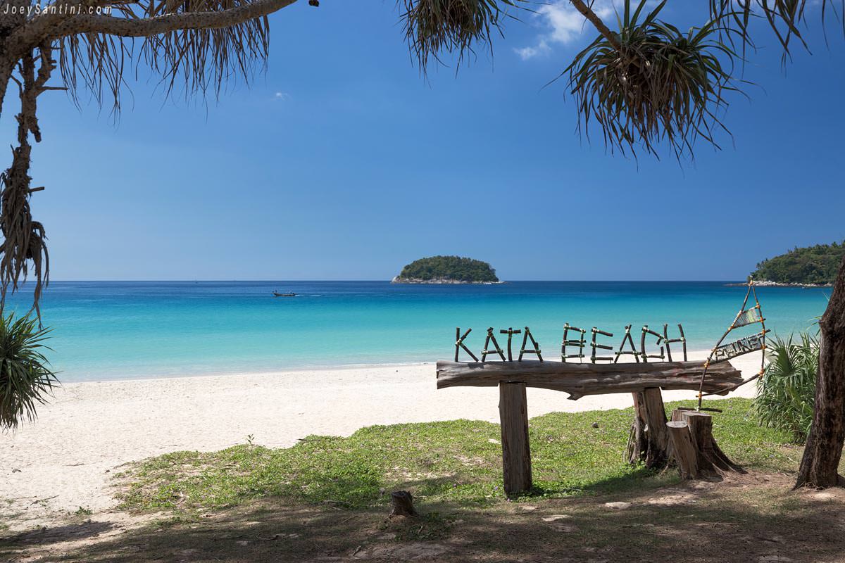 Shot of the wooden sign of Kata beach with blue sky in the background