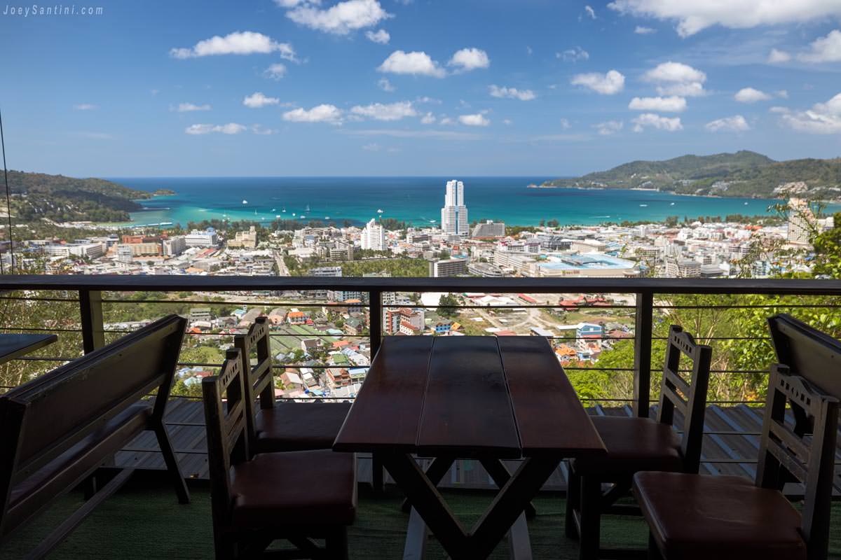 Outdoor dining table on the terrace overlooking turquoise waters of Patong Beach during the day