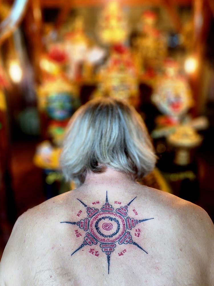 Showing a black Sak yant tattoo and white skin