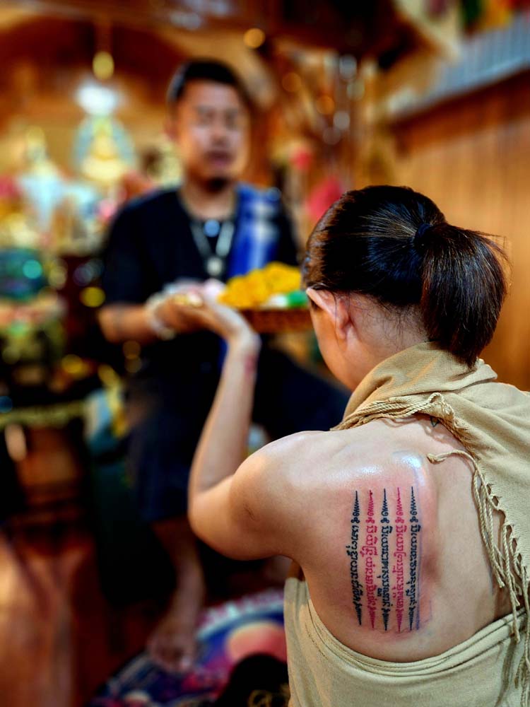 Showing tree black lines and two red lines tattoo and pink skin in the background