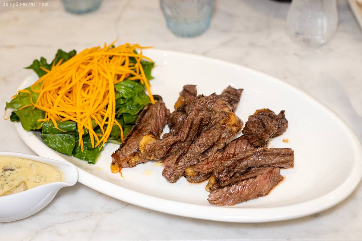 Showing white plate and orange carrot and brown grilled meet