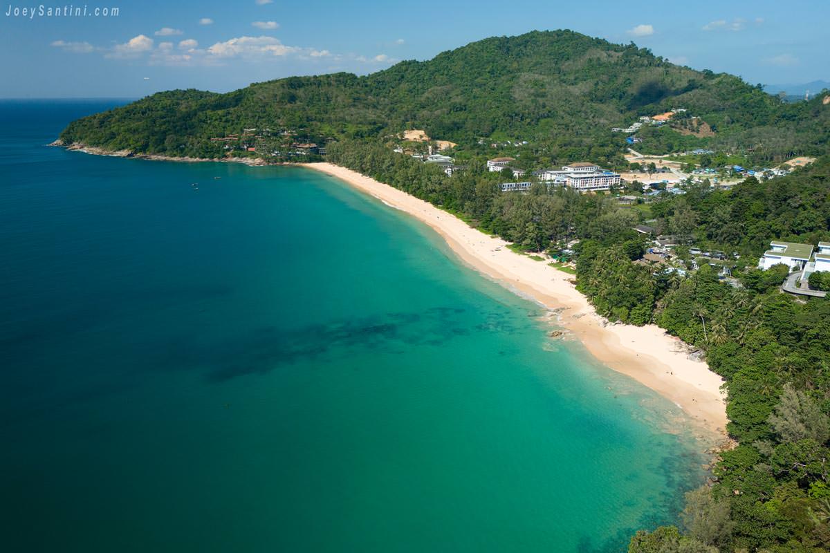 Aerial panoramic view of Naithon Beach coastline with turquoise Andaman Sea waters in Phuket