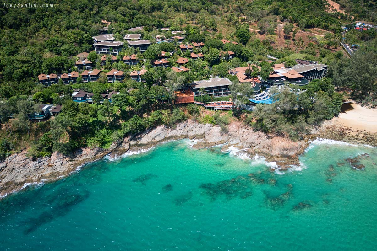 Aerial drone view of Pullman Phuket Arcadia resort perched on the rocky headland of Naithon Beach