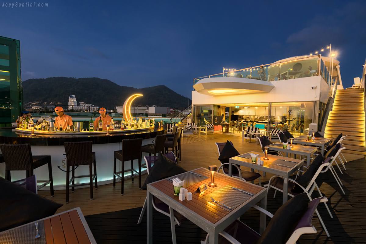 Circular cocktail bar and dining tables at KEE Sky Lounge rooftop in Patong during twilight.