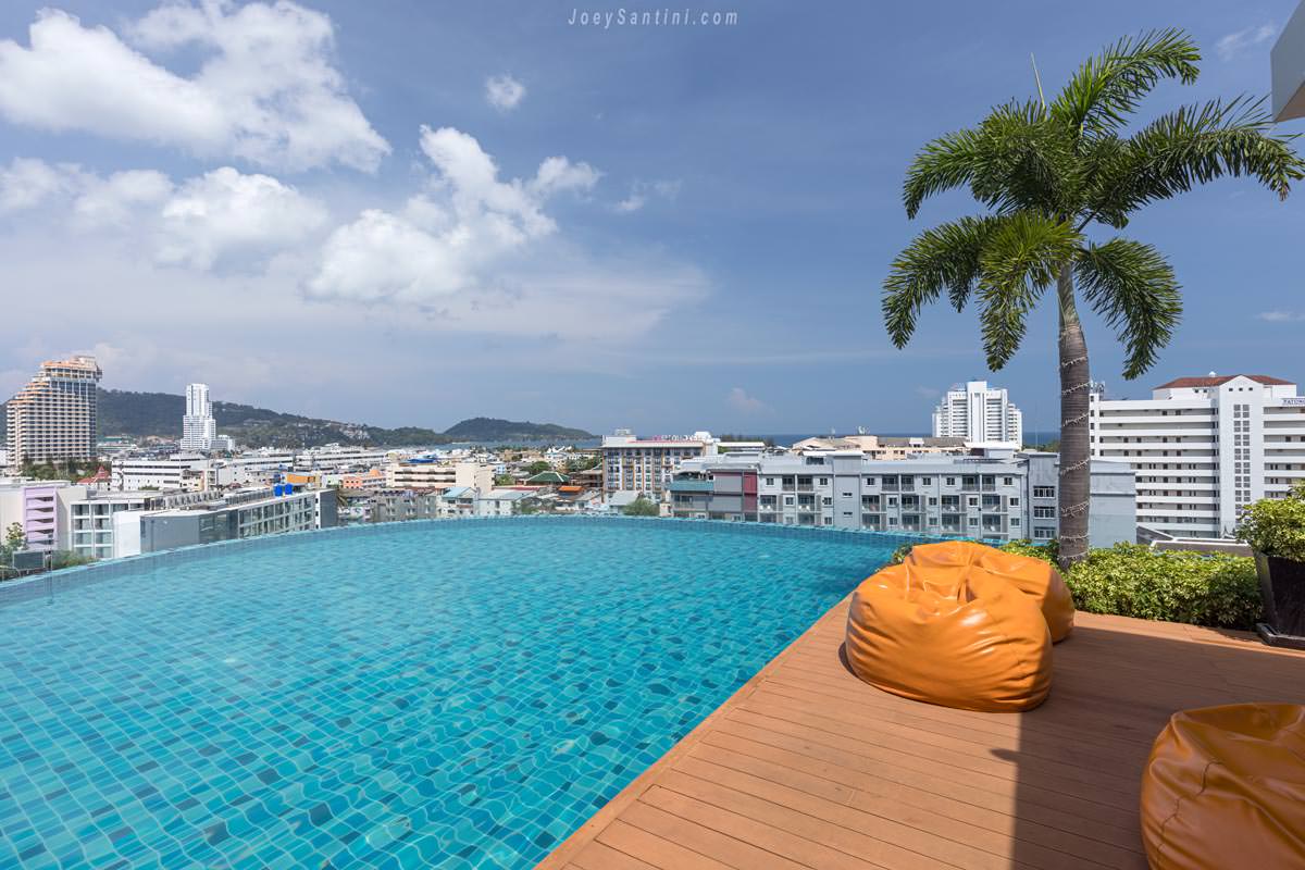 Orange bean bags on the wooden deck next to the rooftop infinity pool at Skyline Rooftop Marina Phuket.