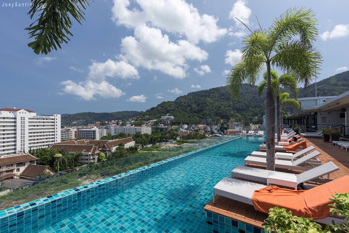 Stunning side view of the rooftop infinity pool at Skyline Rooftop Marina Phuket facing lush green mountains.