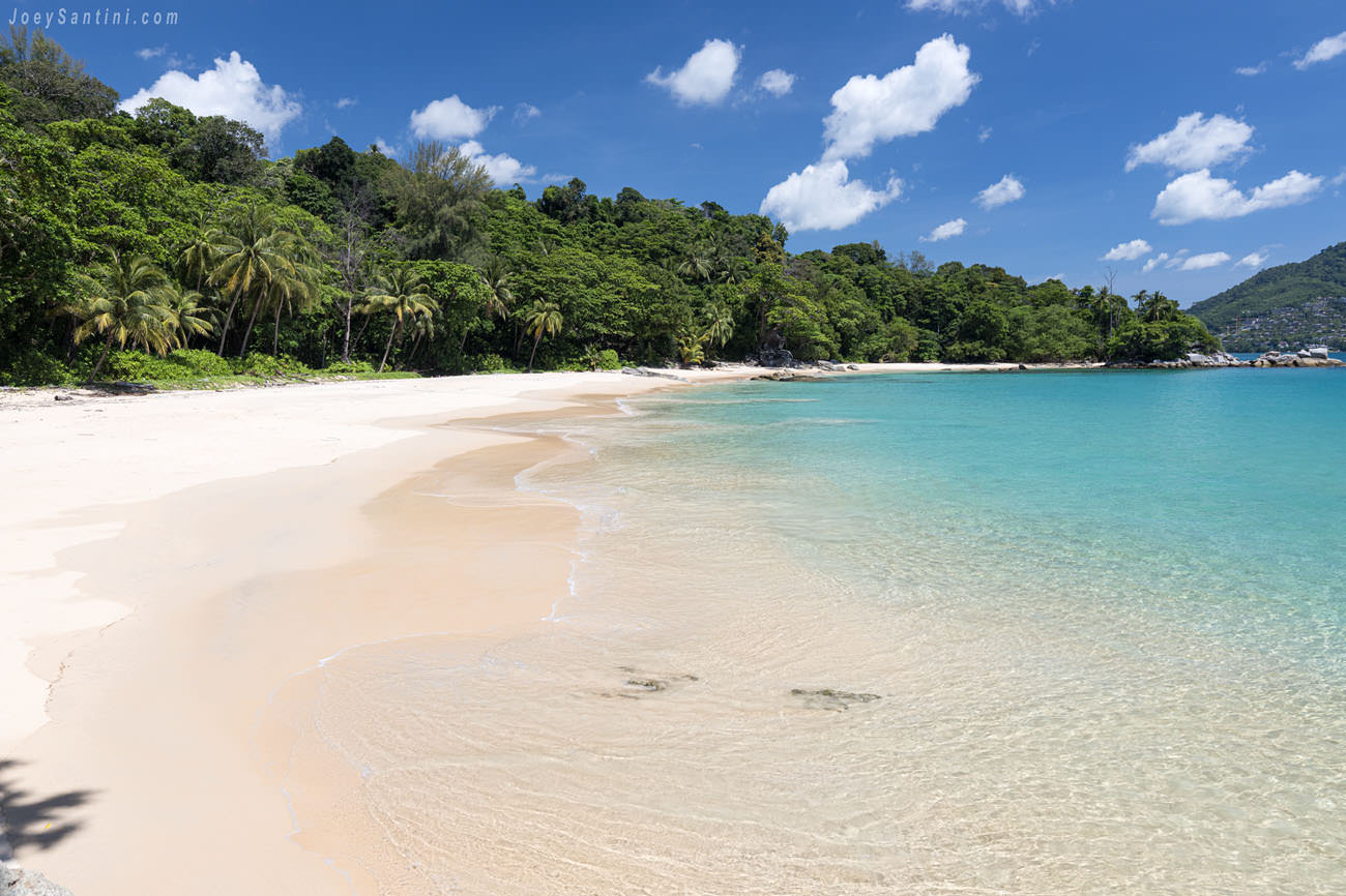 Showing white sand and cyan sea waters and blue sky in the background