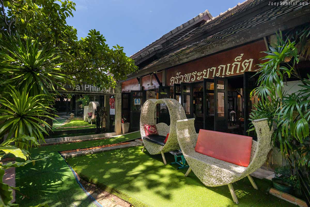 Woven outdoor chairs and relaxing garden lounge seating at Krua Praya Phuket