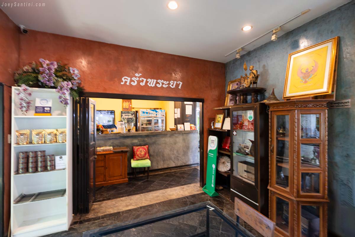 Rustic reception desk and display cabinet inside Krua Praya Phuket restaurant