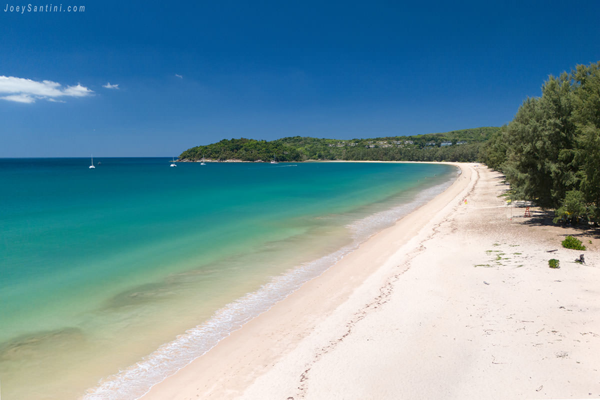 aerial view of layan beach phuket with turquoise sea and pine trees