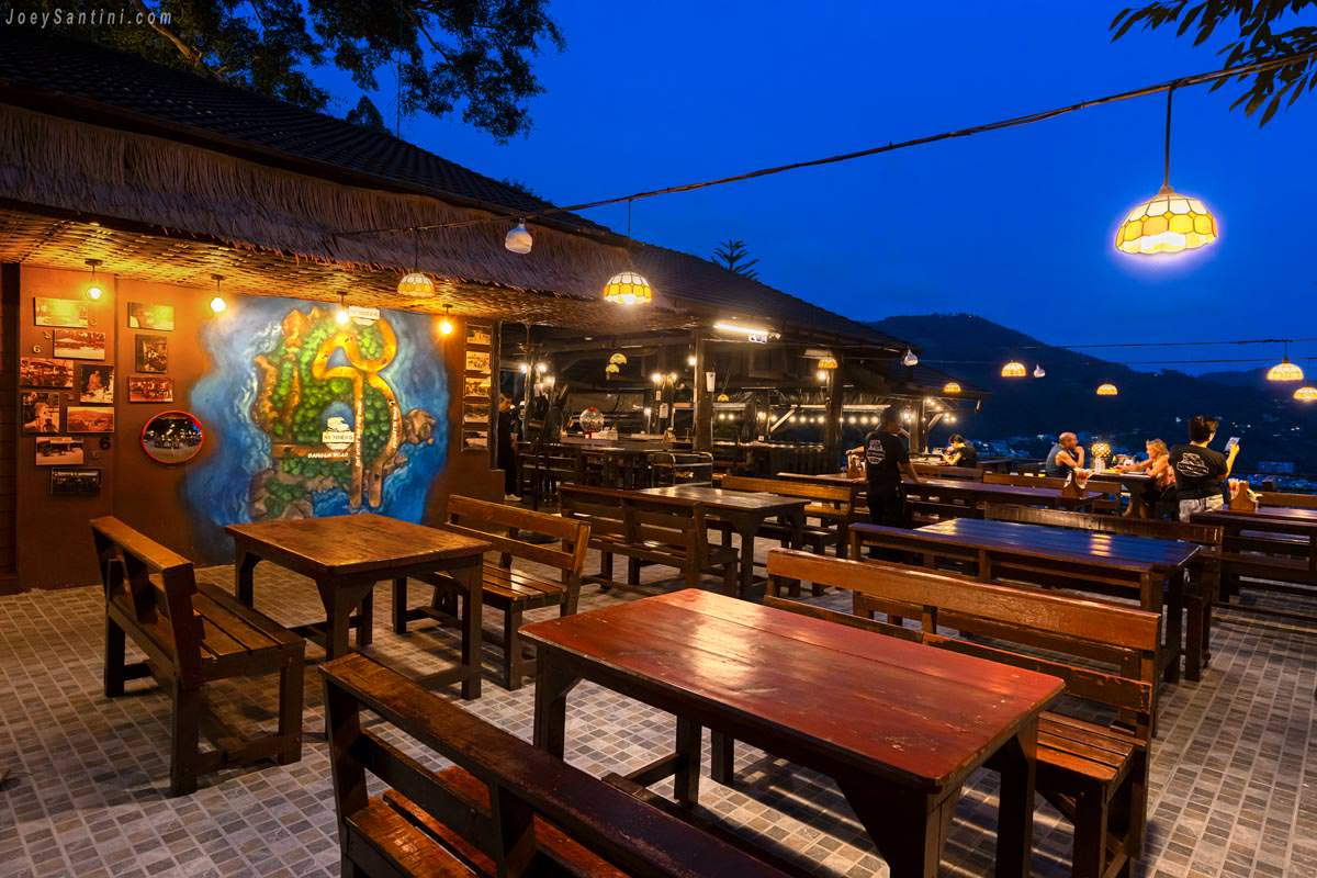 No 6 Restaurant Up The Hill Patong terrace dining area with map mural at dusk