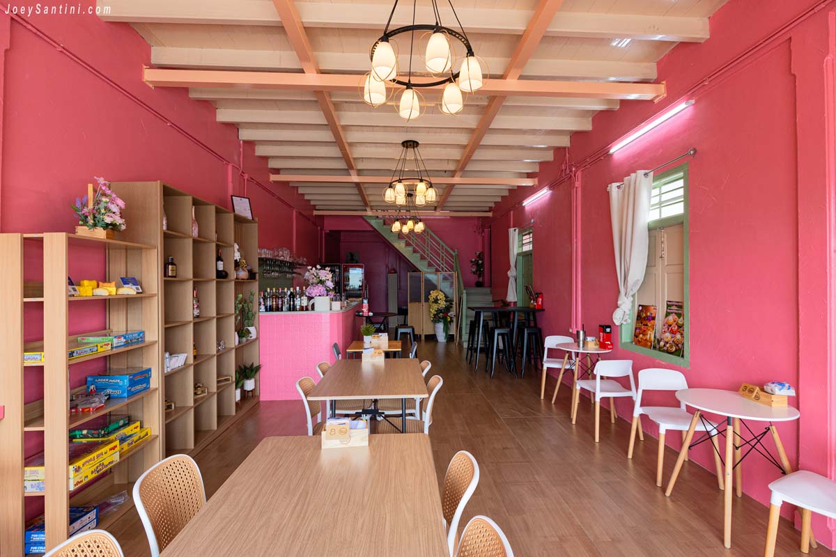 cozy interior layout with wooden ceiling chandeliers and pink walls at sweet come phuket