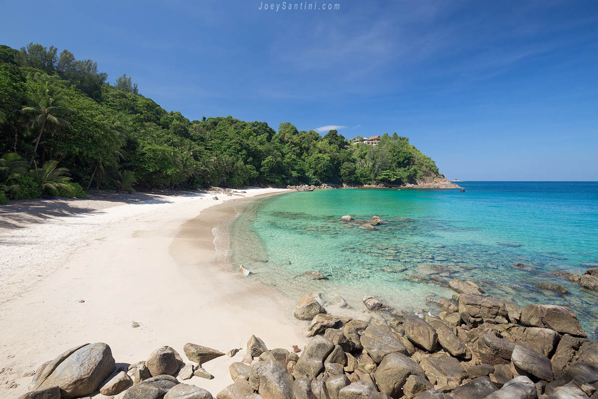 Large granite boulders on the white sand overlooking the turquoise sea at Banana Beach Phuket